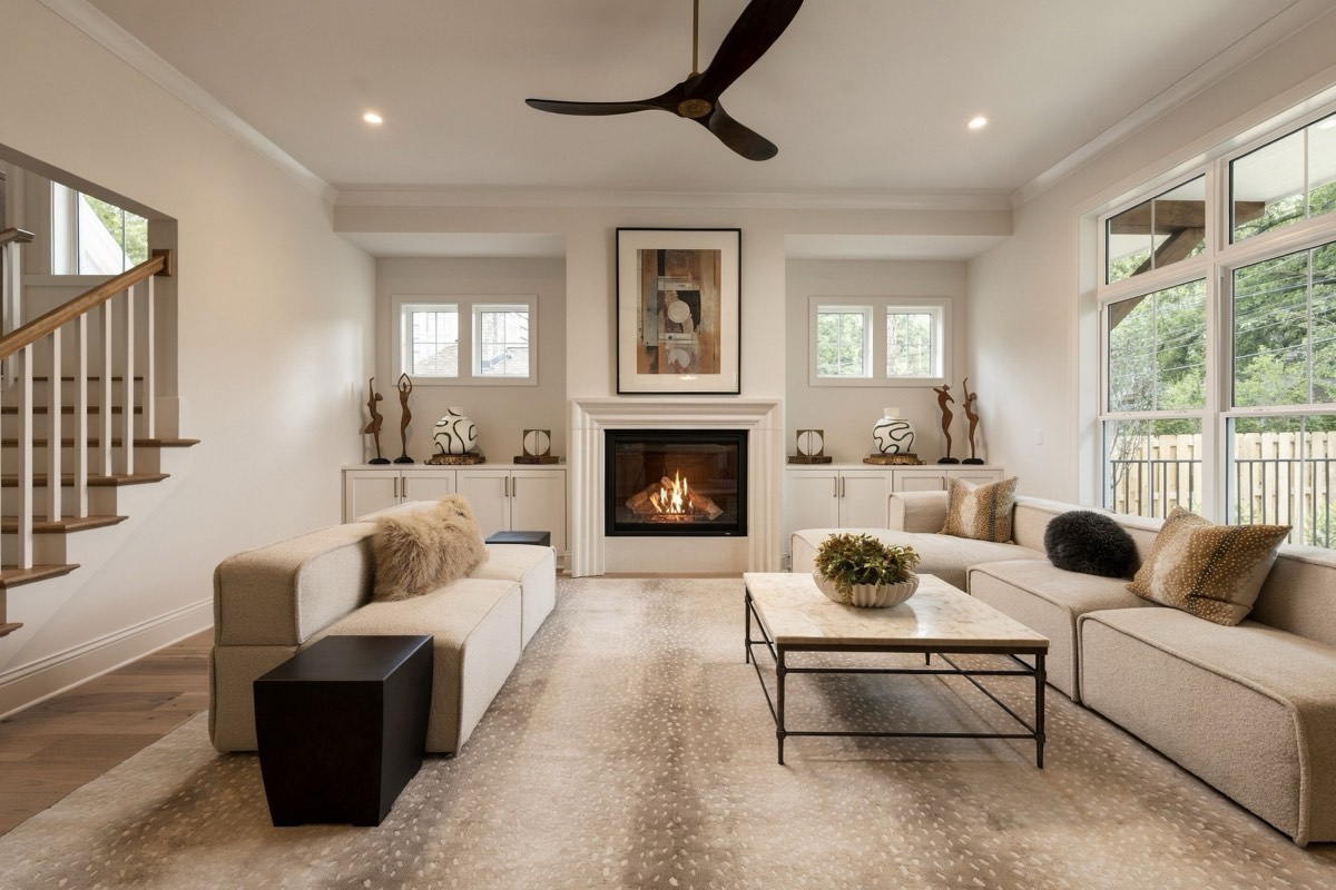 Neutral living room with a lit fireplace and sectional seating