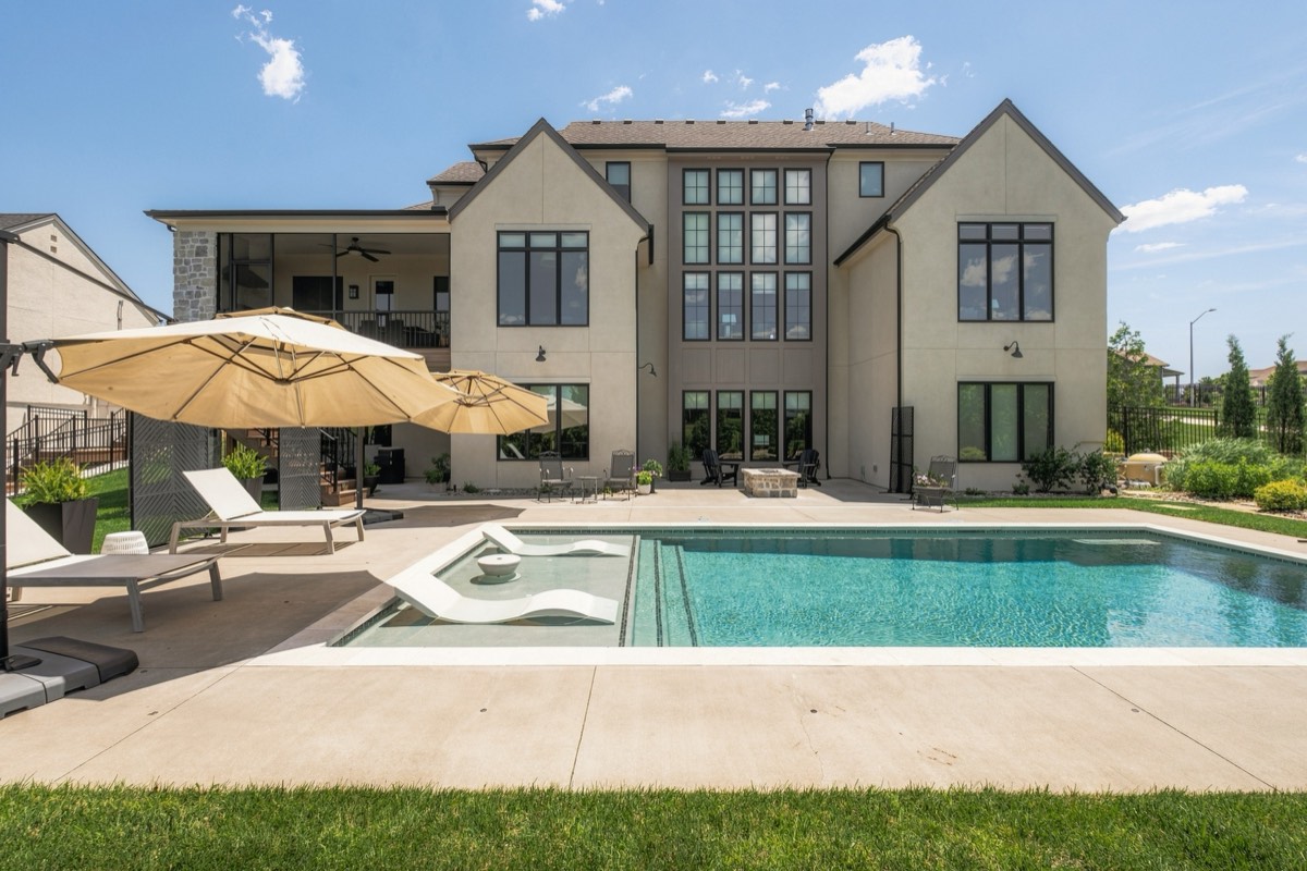 Rear elevation with a pool, in-water loungers and shade umbrellas