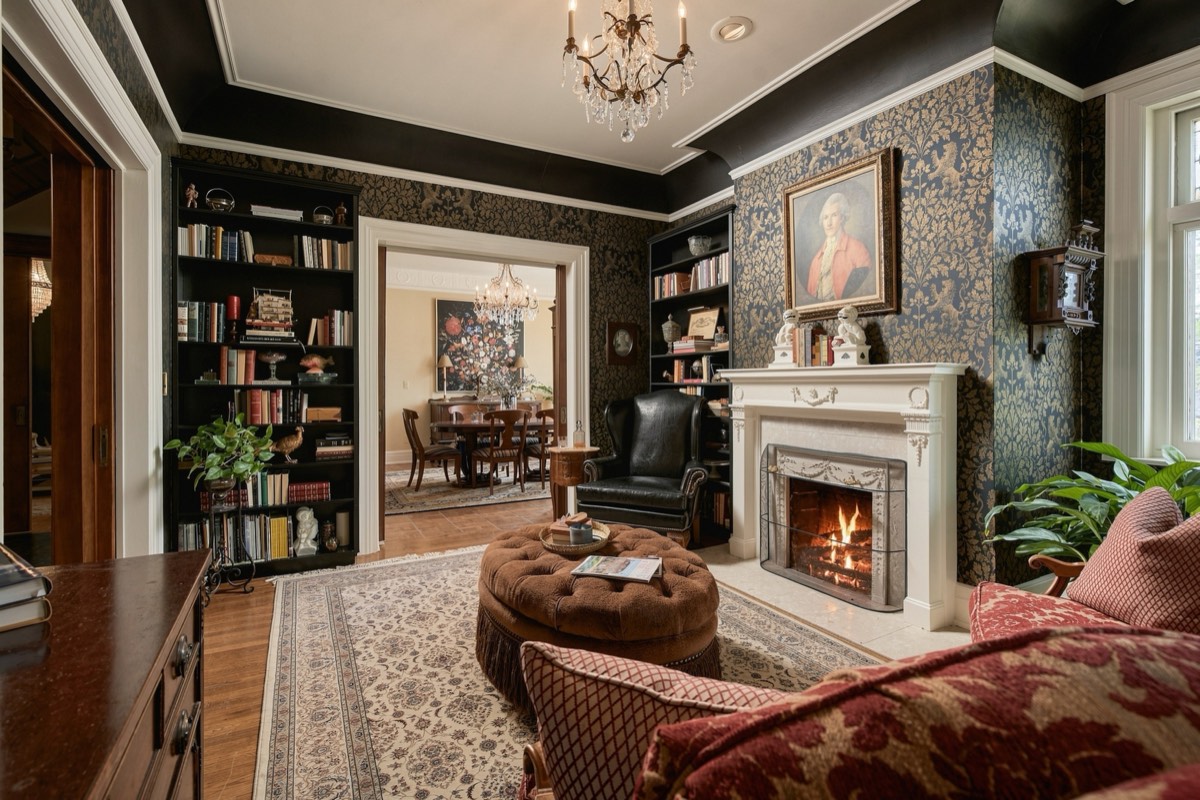 Library with floor-to-ceiling bookshelves and a lit fireplace