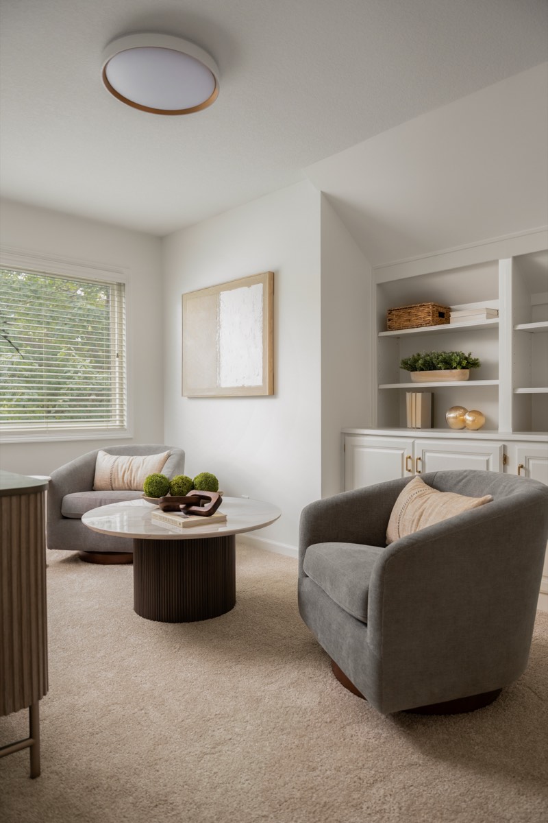 Sitting room with built-in shelving and upholstered swivel chairs