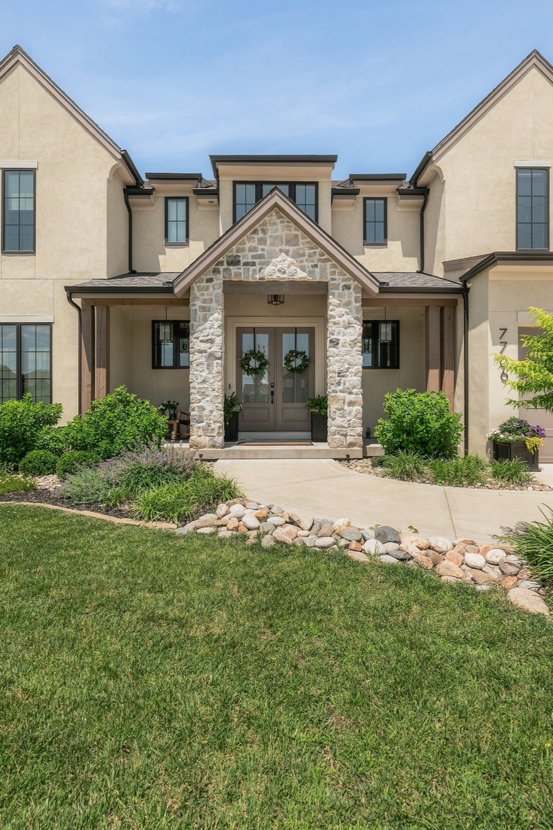 Covered stone entry with a wreathed double door