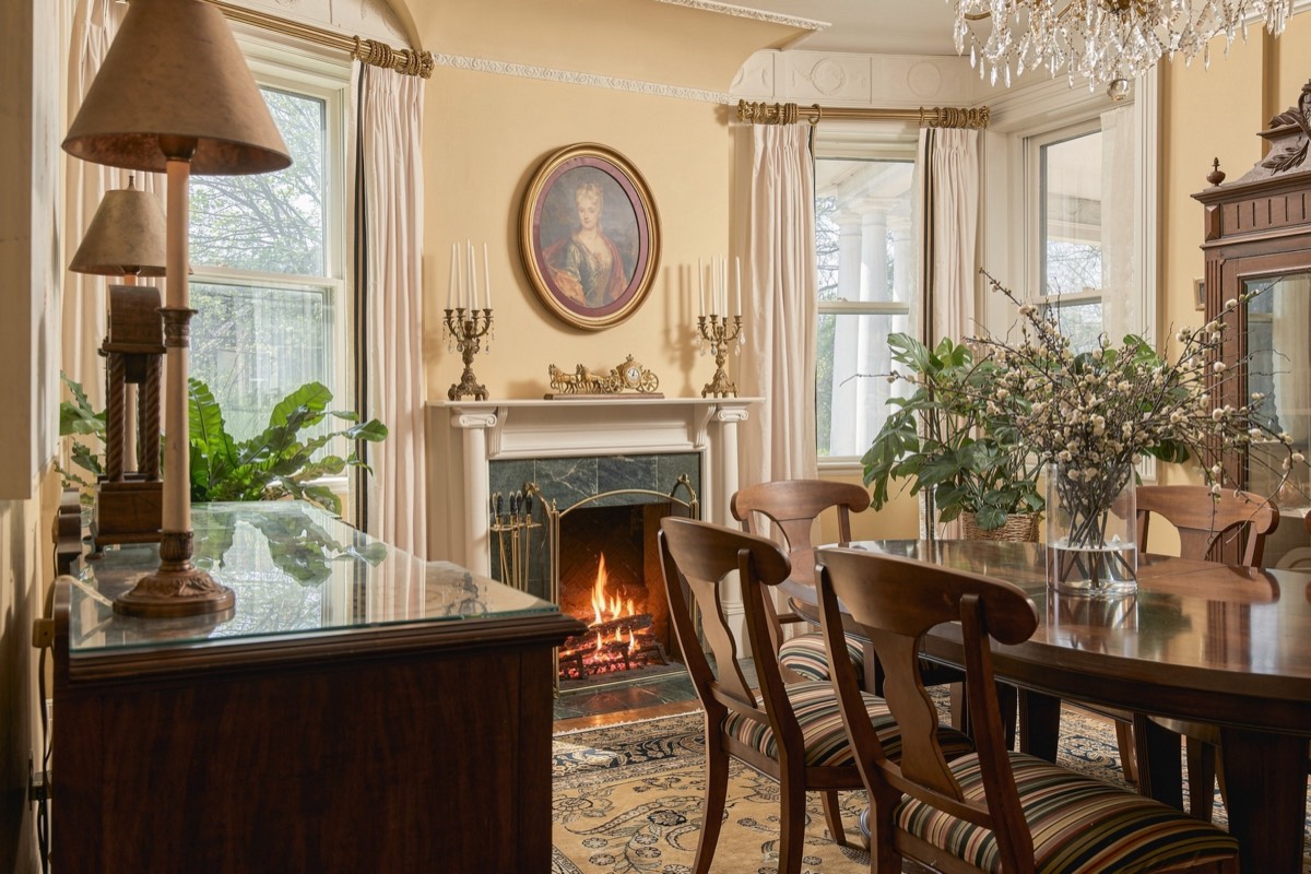 Formal dining room with a lit fireplace and a crystal chandelier