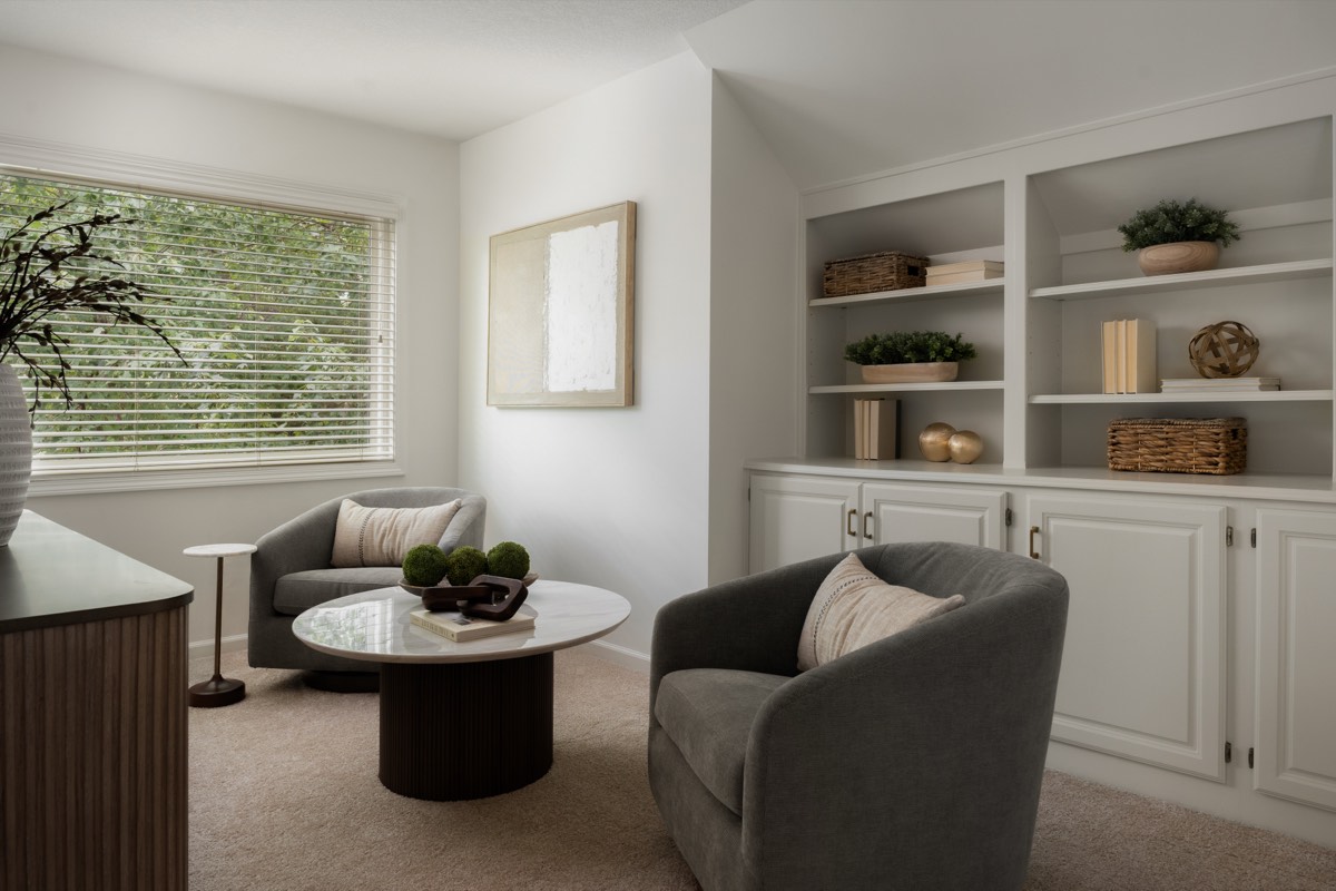 Sitting room with built-in cabinetry and a round marble table